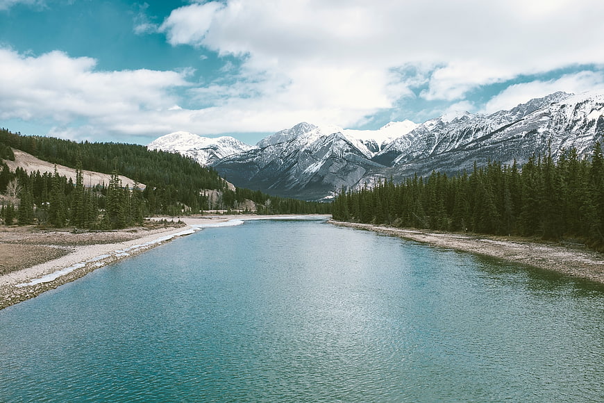 Scenic turquoise river flowing through mountain valley with snow-capped peaks