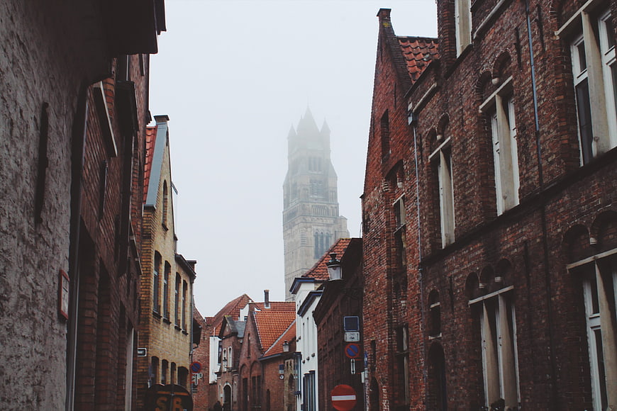 Foggy European Street with Brick Buildings and Distant Tower