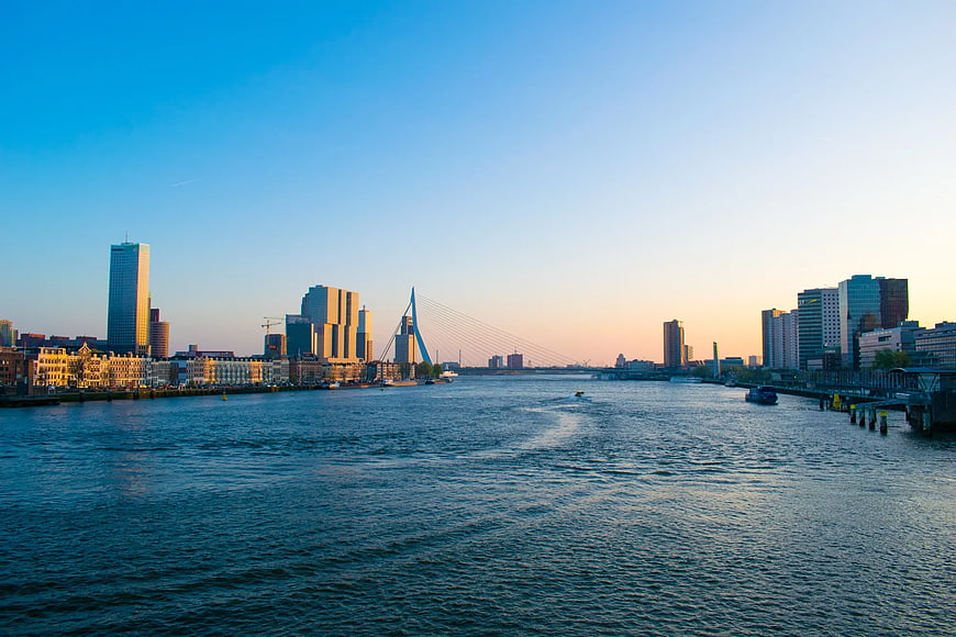Rotterdam skyline with Erasmus Bridge over river at sunset