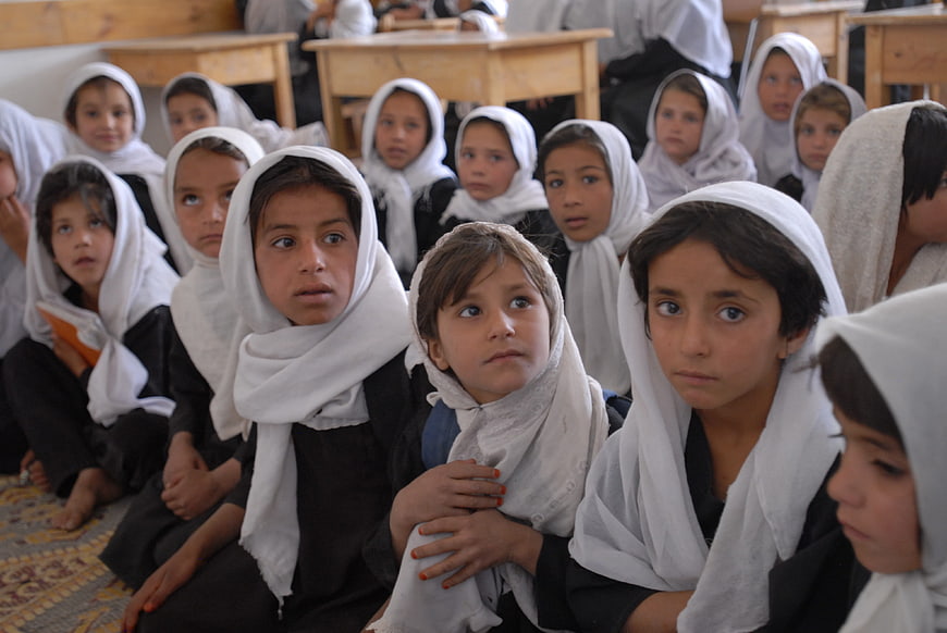 Group of young Afghan girls in classroom with white headscarves