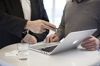 Businessmen discussing work on laptop in office meeting