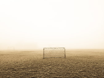 Lonely soccer goal on foggy field