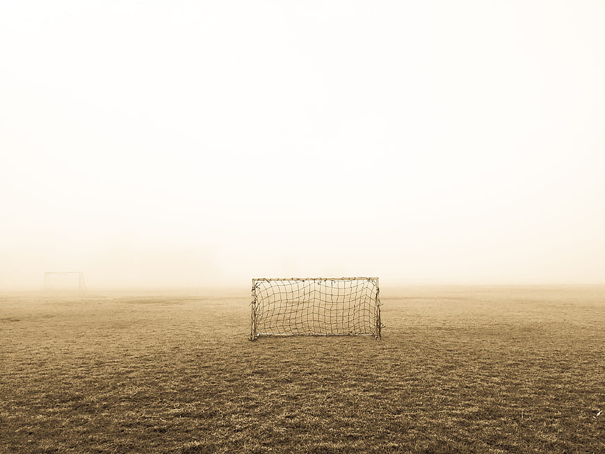 Lonely soccer goal on foggy field