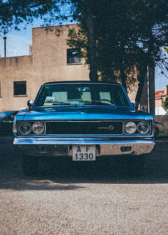 Front view of vintage blue classic car parked outdoors