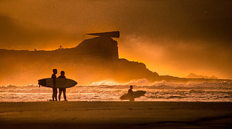 Surfers Silhouetted Against Golden Sunset at Bazaruto Island