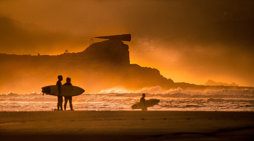 Surfers Silhouetted Against Golden Sunset at Bazaruto Island