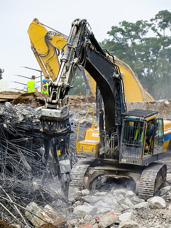 Yellow Excavator Demolishing Concrete Building With Rebar And Rubble