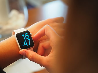 Close-up of woman checking white smartwatch on wrist
