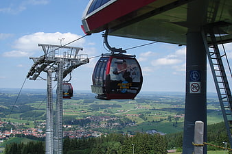 Red Cable Car Station Overlooking Green Valley Landscape