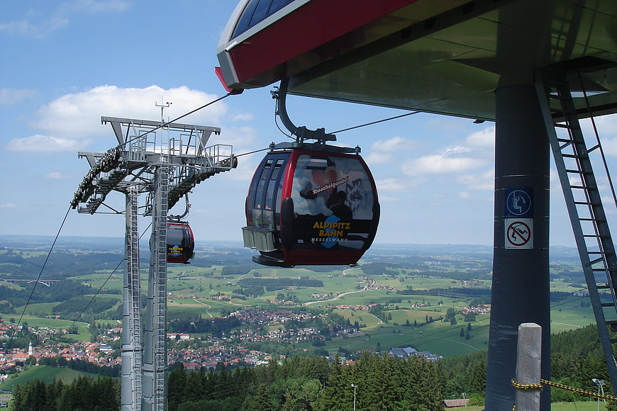 Red Cable Car Station Overlooking Green Valley Landscape