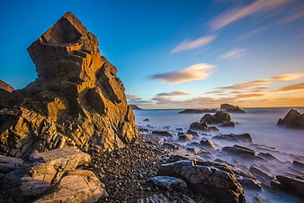 Dramatic coastal rock formation at sunset with long exposure ocean