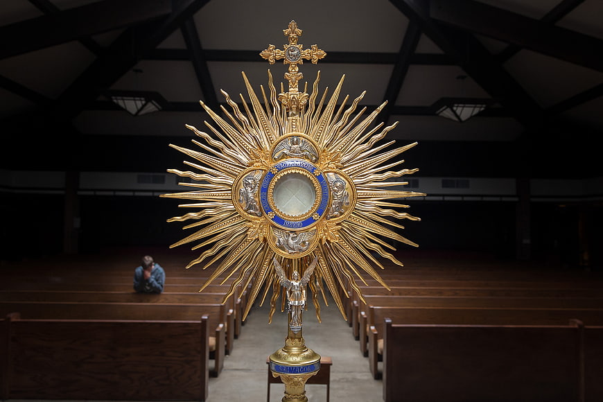 Golden Monstrance in Church with Praying Man
