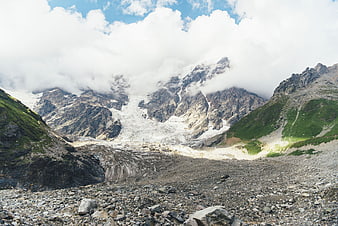 Majestic Alpine Glacier Landscape with Rocky Foreground and Clouds