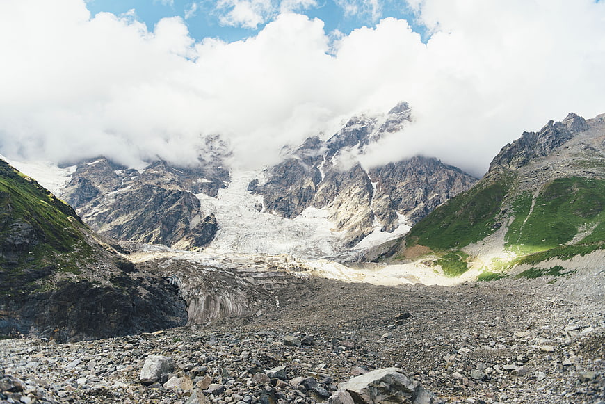 Majestic Alpine Glacier Landscape with Rocky Foreground and Clouds