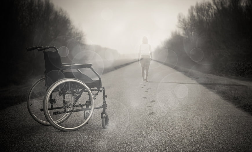 Woman walking away from wheelchair on road