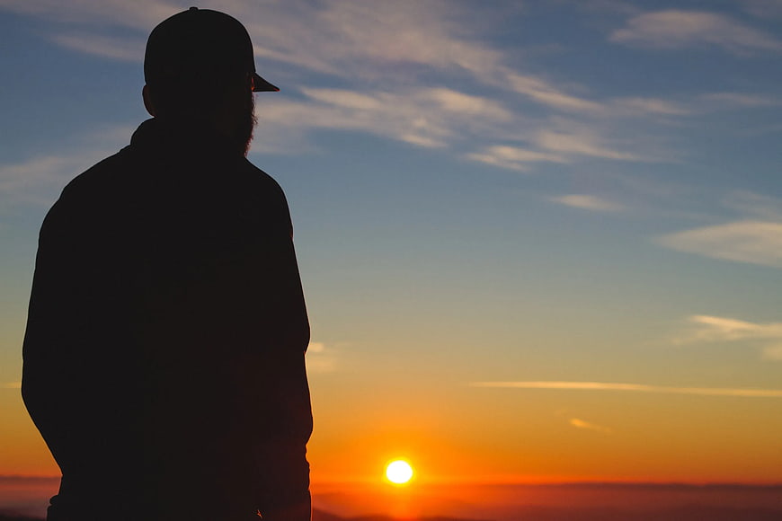 Silhouette of Man Watching Sunset Horizon
