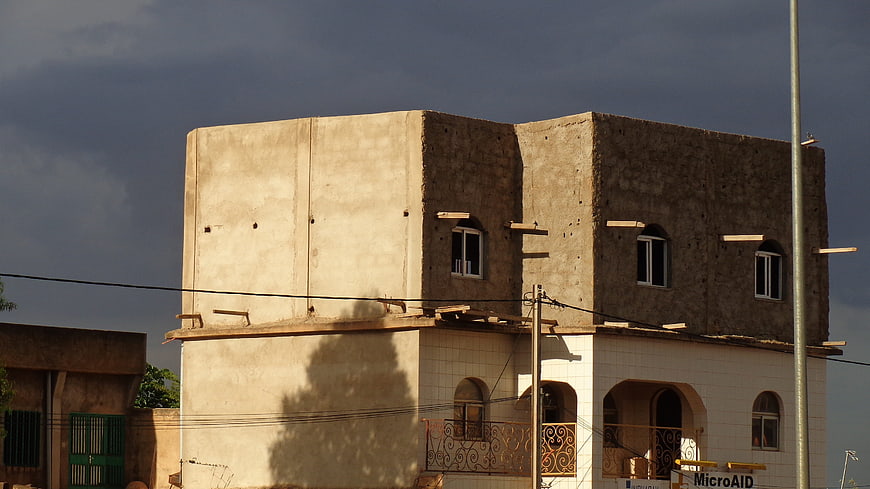 Two-story building under construction with dark stormy sky background