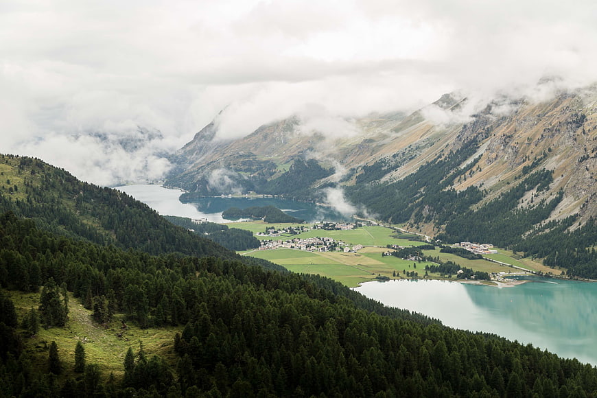 Misty mountain landscape with turquoise lake and village