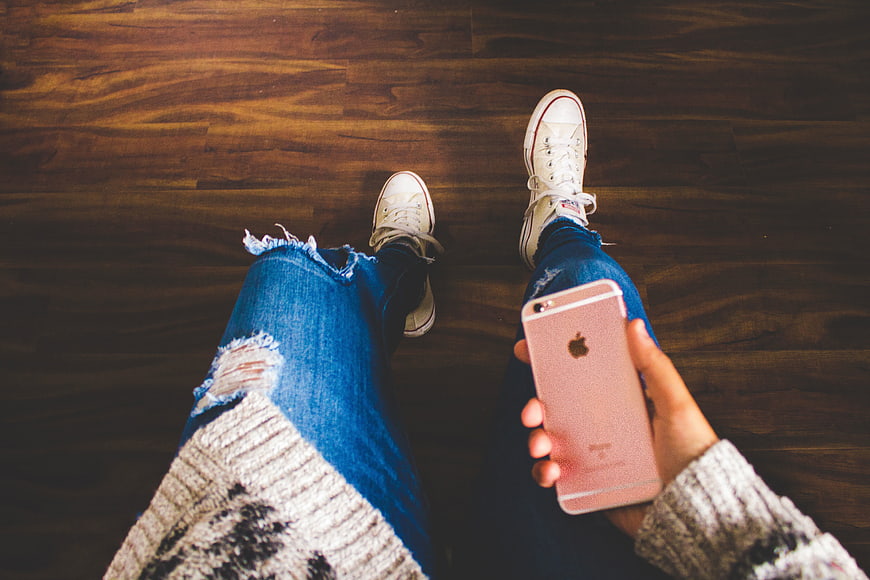 First-person view of woman holding rose gold smartphone