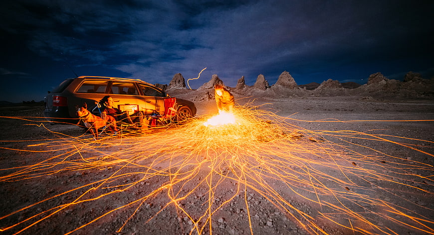 Couple and Dog Camping with Fireworks in Desert Night