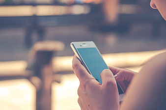 Close-up of hands holding white smartphone with empty screen