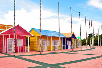 Colorful wooden houses with striped poles in a park