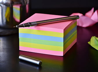 Stack of colorful sticky notes with silver pen on desk
