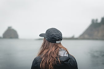 Woman in Black Cap Looking at Ocean Coastline