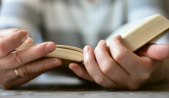 Close-up of hands holding an open book