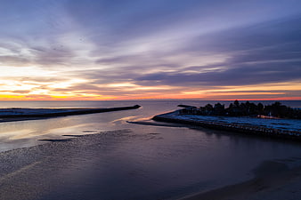 Serene Winter Sunset Over Snowy Coastal Harbor Entrance