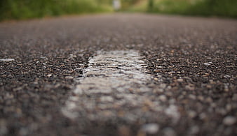 Close-up of worn white line on asphalt road surface