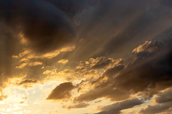 Dramatic Golden Sun Rays Breaking Through Dark Storm Clouds