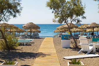 Wooden Pathway to Beach with Thatched Umbrellas and Sunbeds
