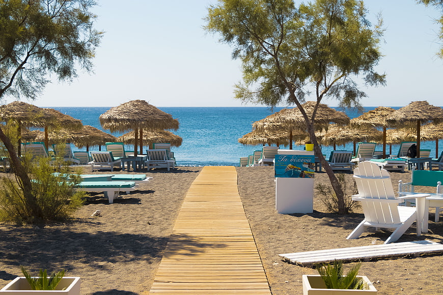 Wooden Pathway to Beach with Thatched Umbrellas and Sunbeds