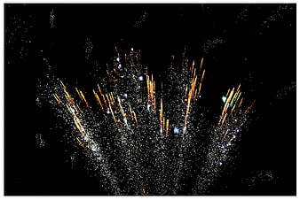 Golden fireworks exploding in the night sky