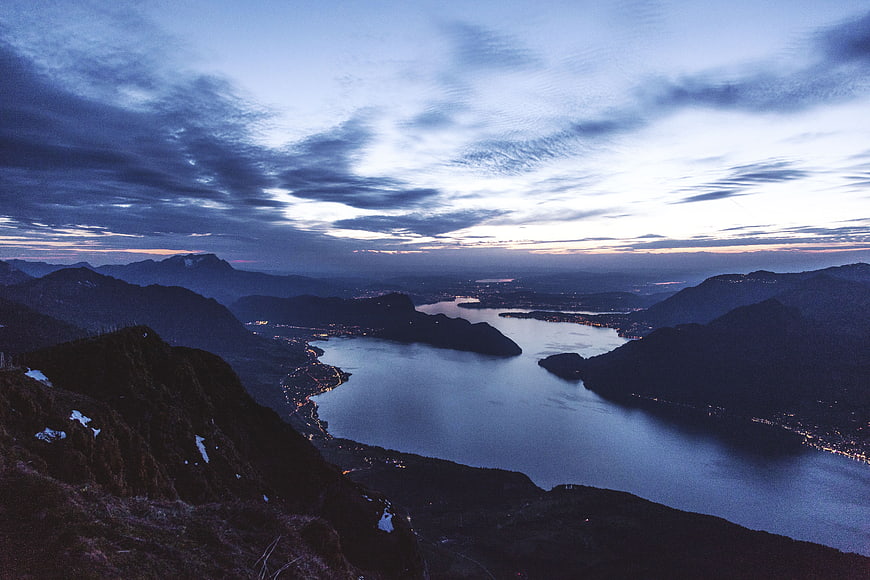 Dramatic Twilight Landscape of Mountain Lake and City Lights