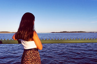 Woman Looking Out at Ocean View from Pier