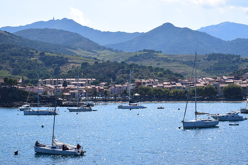 Sailboats in Mediterranean Harbor with Coastal Town and Mountains