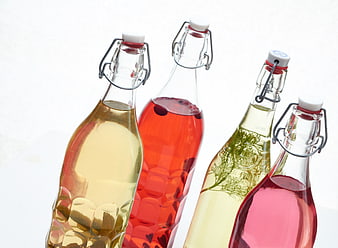 Colorful glass bottles with herbal infusions on white background