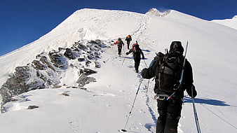Alpine Ski Mountaineering Team Ascending Snowy Mountain Ridge