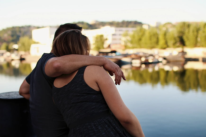 Couple Embracing by Lake at Sunset