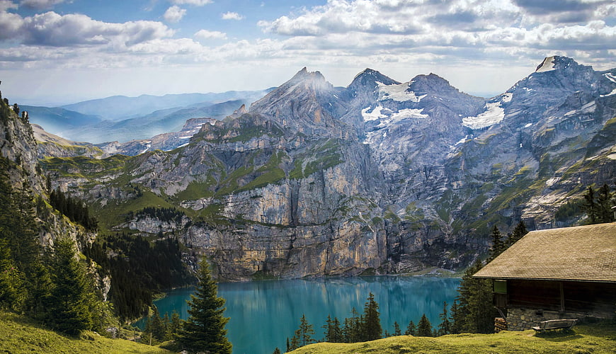 Alpine Lake Oeschinen with Mountain Reflections and Wooden Hut