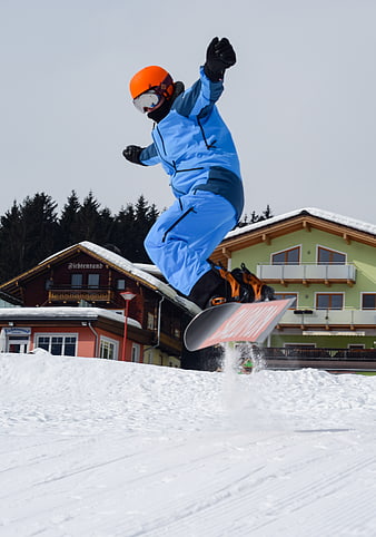 Snowboarder Jumping in Blue Suit at Ski Resort