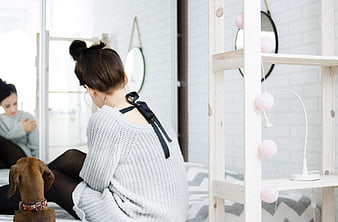 Woman with Dachshund in Bright Minimalist Bedroom Interior