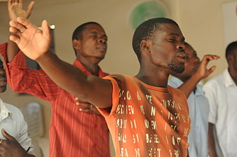 African men worshipping with raised hands in church