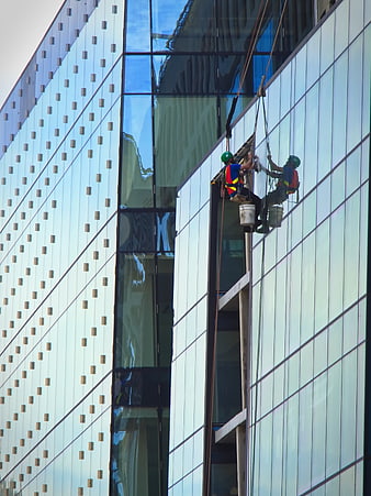 Window Cleaners Hanging on Modern Glass Building Facade