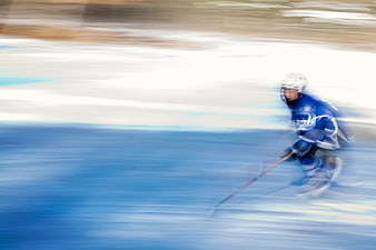 Youth ice hockey player skating on outdoor rink with motion blur