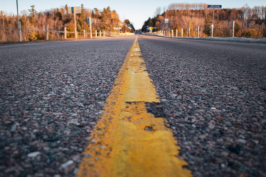 Low angle view of yellow road line on asphalt highway