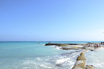 Sunny Beach Scene with Turquoise Water and Rocky Shoreline