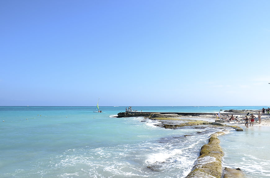 Sunny Beach Scene with Turquoise Water and Rocky Shoreline
